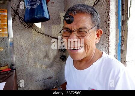 Antipolo City, Philippinen - 29. Januar 2020: Sehen Sie sich den Reparaturmann in seiner provisorischen Reparaturwerkstatt an und lächeln Sie für die Kamera. Stockfoto