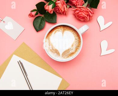 Tasse Kaffee Latte mit Herzform und Valentinen-Deko auf pinkfarbenem Hintergrund Stockfoto