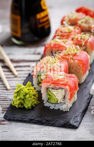 Sushi mit Essstäbchen essen. Sushi Roll japanisches Essen im Restaurant. California Sushi-Rollen-Set mit Lachs. Stockfoto