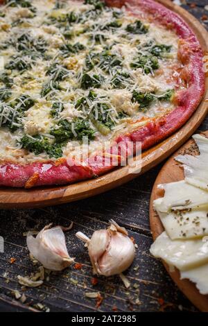 Leckere italienische Pizza auf einem Holztablett Stockfoto