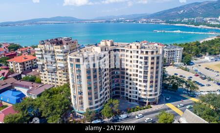 Mehrstöckige Wohnhäuser am Ufer der Gelendzhik Bay. Luftansicht. Sichtbares Meer, Berge, Strand. Erholungsort Leben in der Stadt Stockfoto