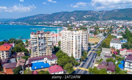 Mehrstöckige Wohnhäuser am Ufer der Gelendzhik Bay. Luftansicht. Sichtbares Meer, Berge, Strand. Erholungsort Leben in der Stadt Stockfoto