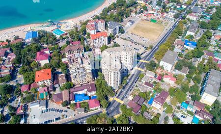 Mehrstöckige Wohnhäuser am Ufer der Gelendzhik Bay. Luftansicht. Sichtbares Meer, Berge, Strand. Erholungsort Leben in der Stadt Stockfoto