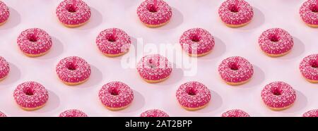 Muster aus Pink Donuts mit Vereisung auf pinkfarbenem Hintergrund. Flacher Lay. Stockfoto