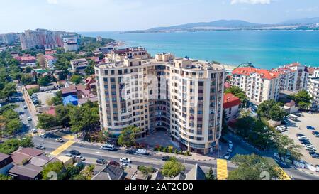 Mehrstöckige Wohnhäuser am Ufer der Gelendzhik Bay. Luftansicht. Sichtbares Meer, Berge, Strand. Erholungsort Leben in der Stadt Stockfoto