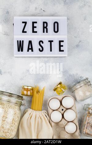 Leuchtkasten mit Aufschrift Zero Waste, eco Natural Bags und Glaskanne mit Essen, umweltfreundlich, flach Lay Draufsicht. Nachhaltige Lifestyle-Konzept. Plas Stockfoto