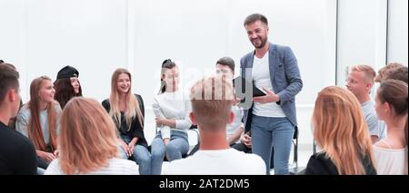 Business Coach stehen in einem Kreis von jungen Menschen. Stockfoto