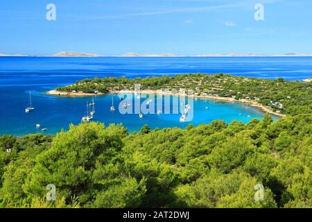 Wunderschöner Strand Kosirina mit klarem türkisfarbenem Meer auf der Insel Murter in Kroatien. Berühmtes Touristenziel, Nationalpark Kornati, am Horizont. Stockfoto