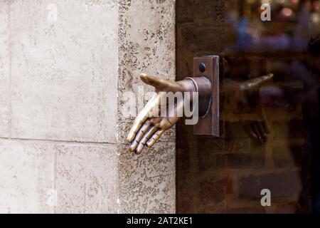 Alter Türgriff aus Metall in Form einer Hand an einer Glastür in Lemberg, Ukraine Stockfoto