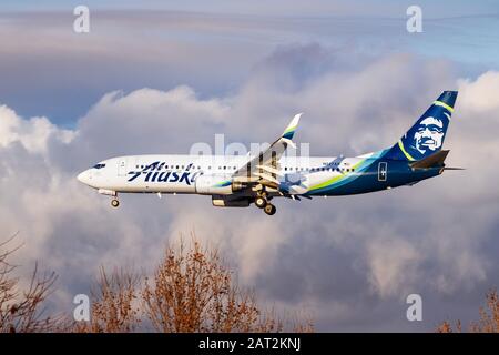 Dezember 2019 San Jose/CA/USA - Flugzeuge der Alaska Airlines, die sich auf die Landung vorbereiten; Sturmwolken im Hintergrund Stockfoto