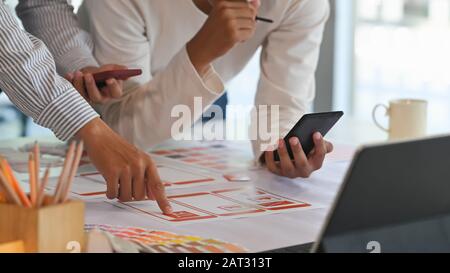 Zugeschnittene Aufnahme des Kreativen UX Ui-Teams bei der Planung/Brainstorming-Arbeit am Schreibtisch. Stockfoto