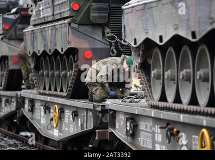 30. Januar 2020, Sachsen, Marienberg: Ein Soldat des Panzergrenadierbataillons 371 aus Marienberg in Sachsen lädt Kampffahrzeuge der 'Marder'-Infanterie auf Eisenbahngüteranhänger. Mit dem Transport fahren Tanks 'Marder', Sanierungstanks 'Büffel' und Radfahrzeuge nach Rukla in Litauen. Das Panzergrenadierbataillon 371 ersetzt dort nach sechsmonatigem Einsatz das Bataillon 391 aus Bad Salzungen. Zum zweiten Mal nehmen die 'Marienberger Jäger' am Vertrag Teil. Hauptaufgabe ist es, gemeinsam mit multinationalen Partnern und den litauischen Streitkräften Präsenz und Praxis zu zeigen. Stockfoto