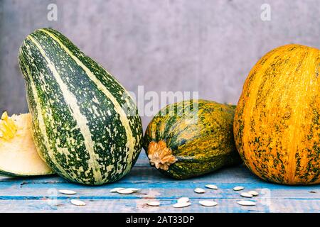 Ein vielfältiges Sortiment an Kürbissen auf blauen alten Brettern. Herbsternte. Stockfoto