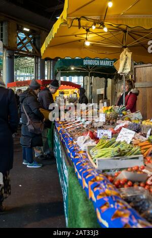 London/Großbritannien - 29. November 2019: Paare, die Gemüse in einem Marktstall am Borough Market wählen, einem der größten und ältesten Lebensmittelmärkte. Heute die Marke Stockfoto