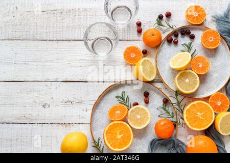 Zitronen, Mandarinen und Orangen auf einem weißen Holztisch. Zubereitung von frischem Saft. Flache Laienansicht mit einem Kopierbereich Stockfoto