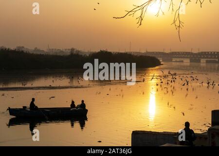 Ruhiger Blick auf den Sonnenaufgang mit einem Boot am Fluss Yamuna in Neu-Delhi Indien Stockfoto