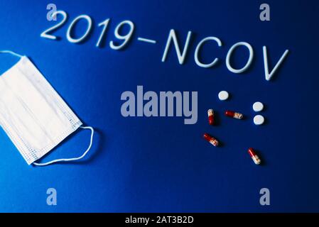 Das Wort 2019-ncov wurde mit weißen Buchstaben auf klassisch blauem Hintergrund mit dramatischem Licht gelegt. Roman-Coronavirus-Krankheit mit dem Namen 2019-nCoV . Pillen und Breat Stockfoto