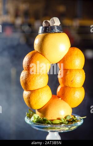 Hookah auf der Orange. Orange Hookah. Hookah mit einem runden durchsichtigen Kolben, in dem in Scheiben geschnittene Orangen und Minzblätter in roter Lauge schweben. Die Kapuzenbuge Stockfoto