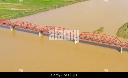 Cagayan River, der nach Volumen größte und der längste Fluss der Philippinen. Die lange Brücke über den Fluss. Autos fahren auf der Brücke, Draufsicht. Stockfoto