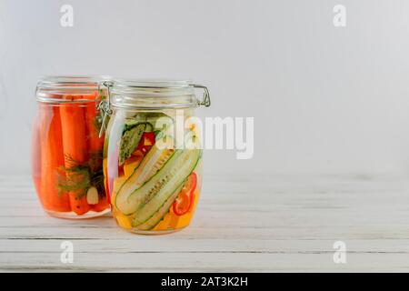 Zwei Glasgefäße fermentierter Karotten, Gemüse auf hellem Hintergrund, Gärung ist eine Quelle von Probiotika. Kopierraum Stockfoto