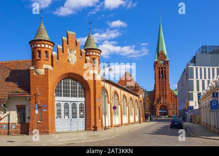 Bydgoszcz, Kujawien-Pommerschen/Polen - 2019/04/01: Vorderansicht des historischen städtischen Marktsaalgebäudes an der Magdzinskiego Straße mit der St. Andrew Bobola Kirche im Hintergrund im Altstadtviertel Stockfoto