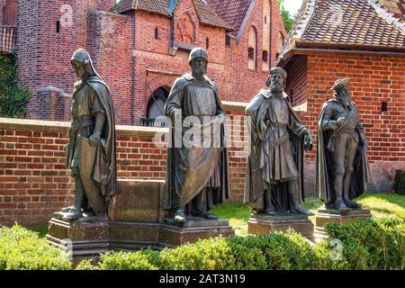 Malbork, Pomerania/Poland - 2019/08/24: Statuen der großen Meister des Deutschen Orden auf dem Innenhof der Festung Mittelburg des mittelalterlichen Schlosses Teuteke in Malbork, Polen Stockfoto