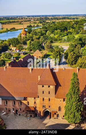 Malbork, Pomerania/Polen - 2019/08/24: Luftpanorama zum Innenhof mit dem Torturm im Mittelschloss Teil der mittelalterlichen Burg des Deutschen Orden am Fluss Nogat in Malbork, Polen Stockfoto