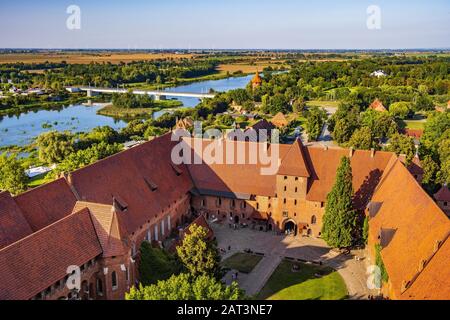 Malbork, Pomerania/Polen - 2019/08/24: Luftpanorama zum Innenhof mit dem Torturm im Mittelschloss Teil der mittelalterlichen Burg des Deutschen Orden am Fluss Nogat in Malbork, Polen Stockfoto