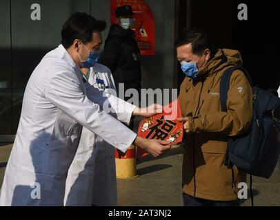 (200130) -- PEKING, 30. Januar 2020 (Xinhua) -- Li Ang (L, Front), Leiter des Pekinger Ditan-Krankenhauses, schickt den chinesischen Charakter "Fu", was Glück bedeutet, an Wang Guangfa (R, Front), Leiter der Abteilung Für Lungenmedizin am ersten Krankenhaus der Peking-Universität in Peking, Hauptstadt Chinas, 30. Januar 2020. Wang wurde geheilt und aus dem Krankenhaus entlassen. Er war der fünfte mit Coronavirus infizierte Patient, der in Peking geheilt wurde. (Xinhua/Ren Chao) Stockfoto