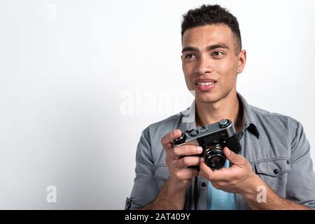 Portrait des fröhlichen Mulatto Menschen mit Vintage-Fotocamera. Touristisches Konzeptbild. - Kopierbereich Stockfoto