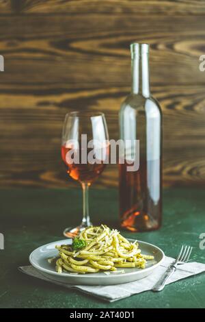 Spaghetti pasta Bucatini mit Pesto und Parmesan. Traditionellen italienischen perciatelli Pasta mit Pesto Genovese in grauen Schale mit Wein serviert. Stockfoto