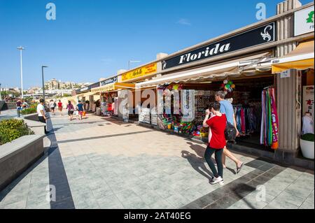 KANARENINSEL TENERA, SPANIEN - 26 DEC, 2019: Touristen gehen entlang der Geschäfte am Boulevard Playa de Fanabe auf der Kanareninsel Tenera. Stockfoto