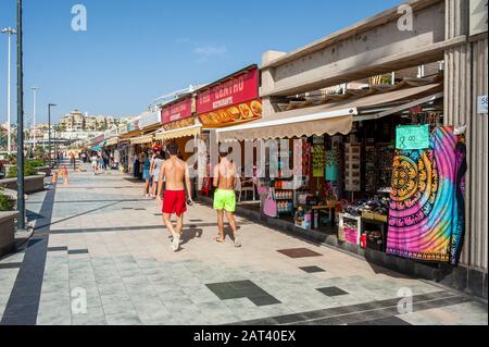 KANARENINSEL TENERA, SPANIEN - 26 DEC, 2019: Touristen gehen entlang der Geschäfte am Boulevard Playa de Fanabe auf der Kanareninsel Tenera. Stockfoto