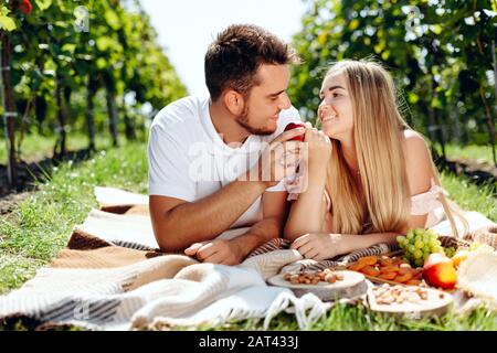 Liebendes junges Paar auf Pflaumen im traubengarten liegend Stockfoto