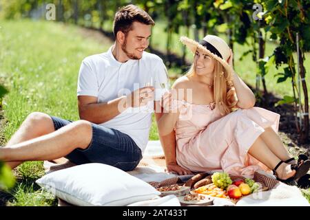 Ein junges Paar teilt einen glücklichen Moment Picknick auf dem Rasen auf dem Lande Stockfoto