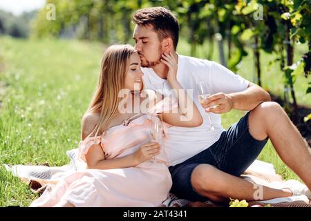 Junges Paar küsst sich in einem Weinberg. Stockfoto