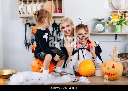 Glückliche Familienvorbereitungen zu Halloween. Junge mit lächelnder Zunge und Frau Stockfoto