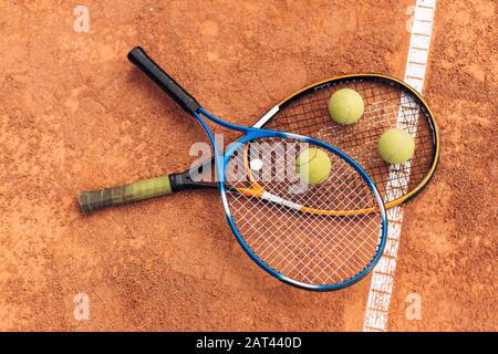 Drei gelbe Tennisbälle liegen auf Schläger durch weiße Linie Stockfoto