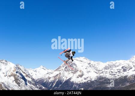 Akrobatischer Sprung auf die Skier in der Winterlandschaft Stockfoto