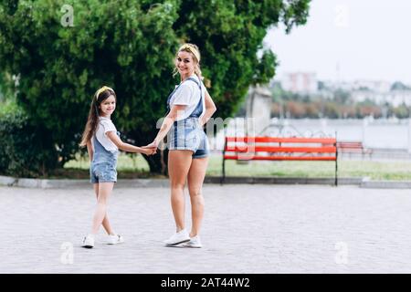 Mutter und Tochter schütteln die Hände zurück und schauen auf die Kamera Stockfoto