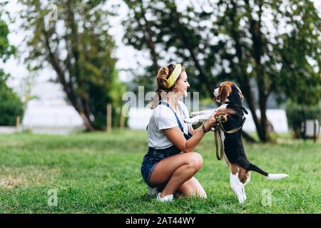 Frau, die mit einem Hund spazieren geht und mit ihm spielt. -Bild Stockfoto