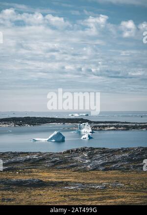 Magische Arcticlandscape am Arktischen Ozean in Grönland. Eisberge schwimmen im Wasser. Blauer Himmel an einem Sommertag. Stockfoto