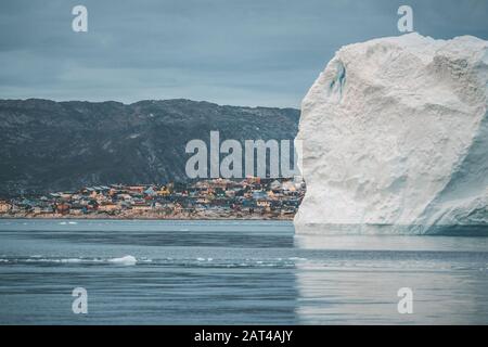 Grönlandgletscher mit Meereis und riesigem Eisberg vor der arktischen Stadt Ilulissat. Gletscherlandschaft in der Nähe des berühmten Icefjord im Westen grönlands Stockfoto