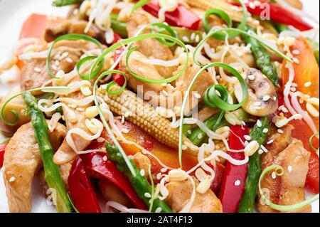 Hähnchenchop Suey auf weißem Teller. Chop Suey ist ein amerikanisches chinesisches Gericht mit verschiedenen Rührgemüse, Hühnerfleisch und Soßen. Nahaufnahme Stockfoto