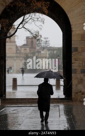 Ein Mann spaziert an einem regnerischen Tag in Valencia. Stockfoto