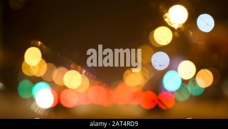 Abstrakter Hintergrund verschwommener Städte. Verschwommene Bokeh-Beleuchtung, Straßenbeleuchtung und Autoscheinwerfer Stockfoto