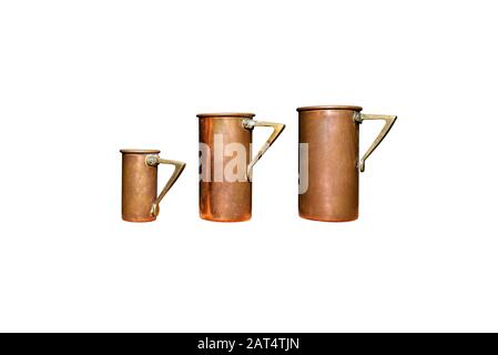 Vintage, zwei große und eine kleine Tasse für Getränke aus Kupfer und Messing, isoliert auf weißem Hintergrund mit einem Beschneidungspfad. Stockfoto