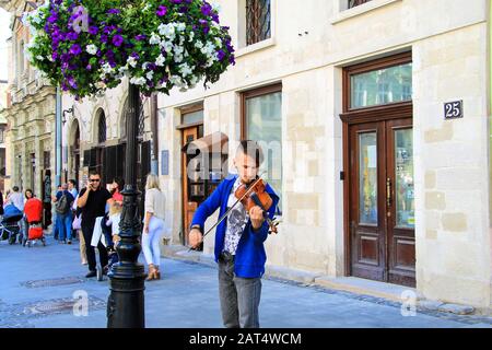 Lemberg, Ukraine, 04 07 2019 EIN junger Mann spielt die Geige auf einer historischen Straße in Lvov. Der Musikerviolinist führt klassische Musik für Touristen auf Stockfoto