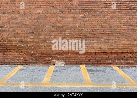 Eine Wandallee aus rotem Backstein mit gelber Ladezone Stockfoto
