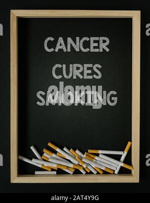 Krebs kuriert die rauchende Nachricht mit Haufen Zigaretten und Holzrahmen beendigte das Rauchen Konzept schlechte Gewohnheitssucht Stockfoto